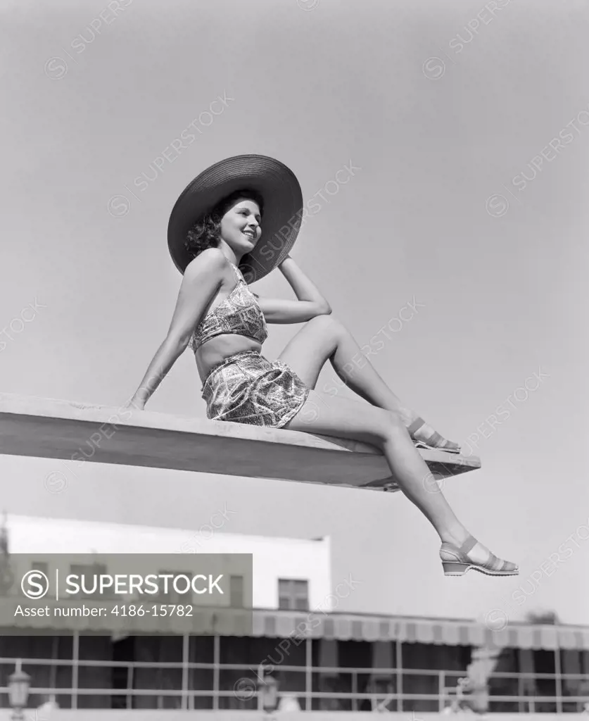 1930S Woman Wearing Hat Sitting Near Edge Of Diving Board
