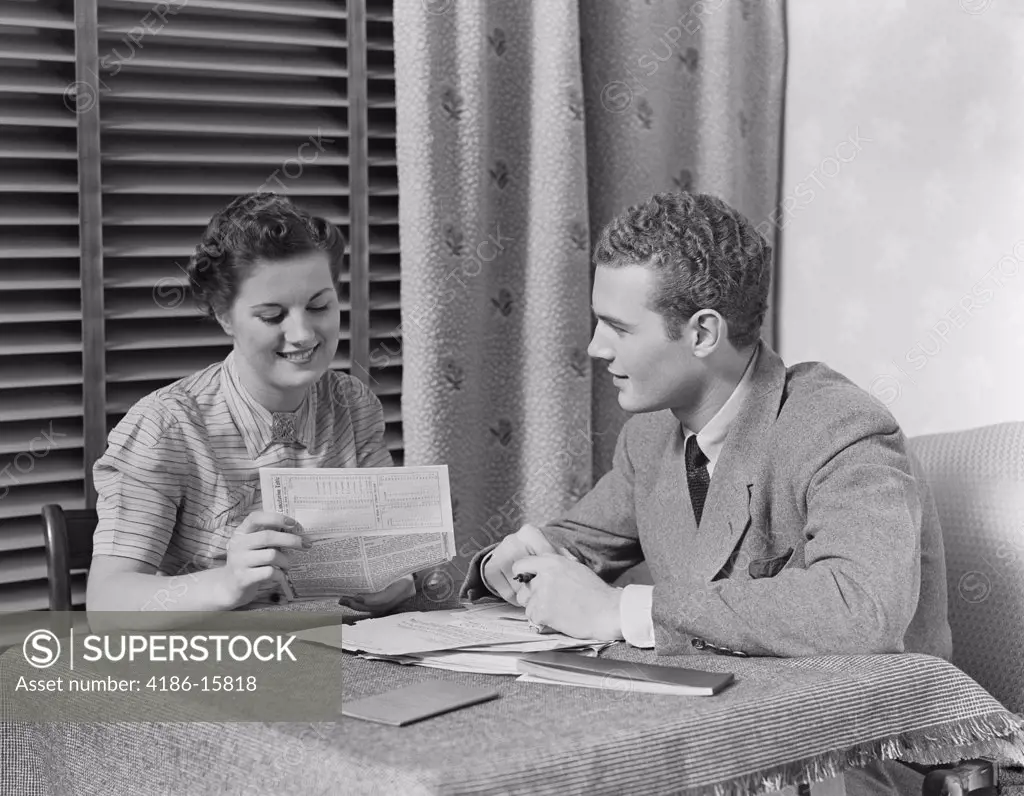 1930S Couple Man Woman Sitting At Table Going Over Papers 