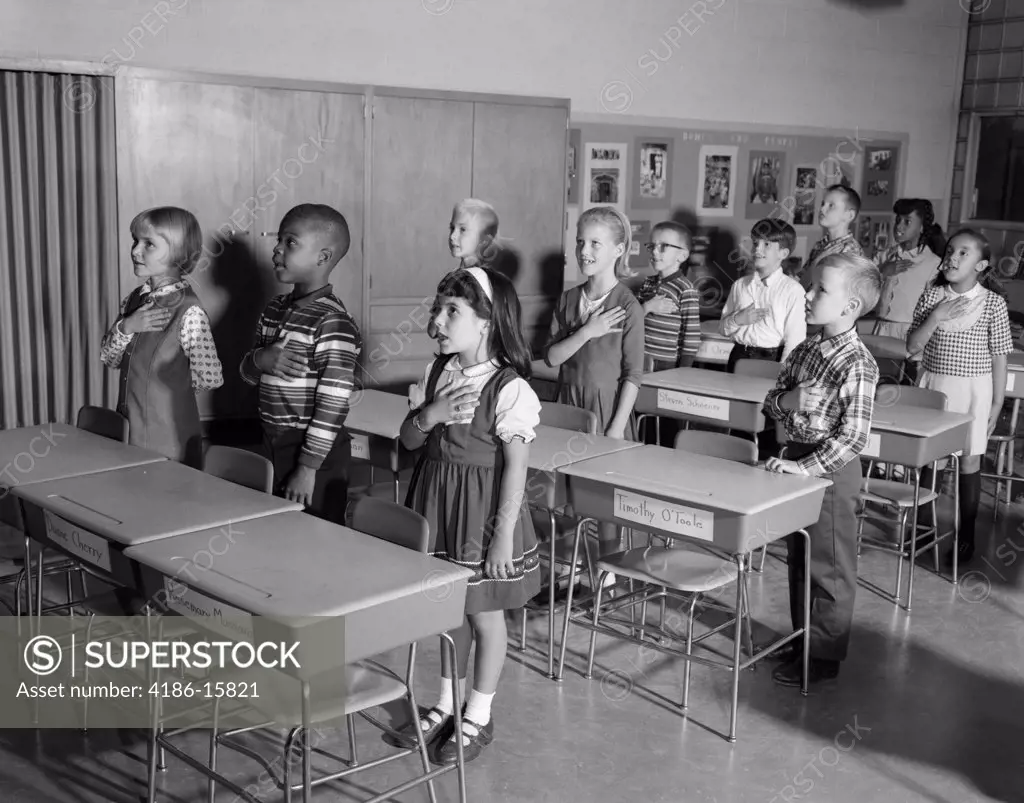 1960S Kids Saying Pledge Of Allegiance In Classroom
