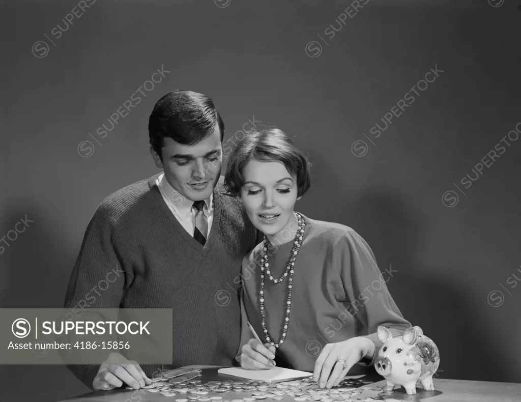 1960S Couple Counting Coins From Piggy Bank