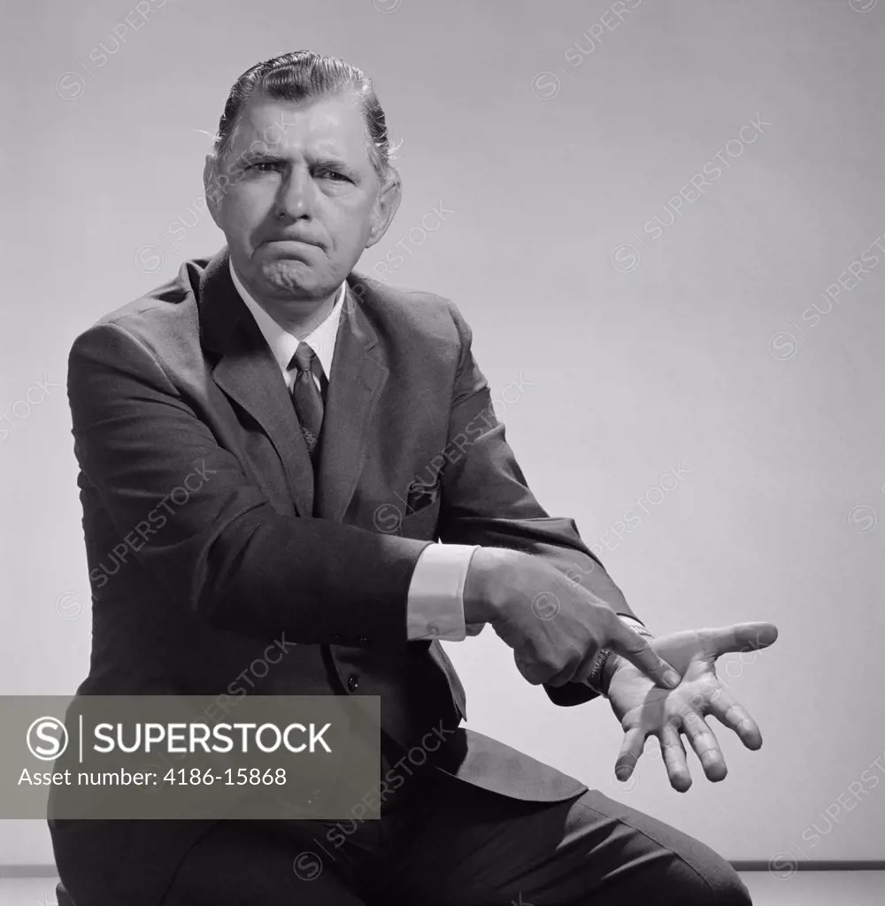 1960S Angry Man Pointing To Palm Of His Hand