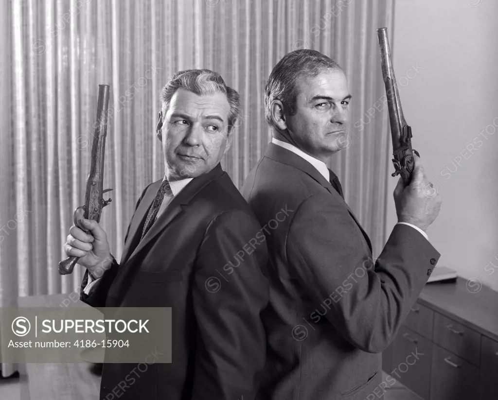 1960S 2 Middle Aged Men Back To Back Holding Duel Pistols Guns