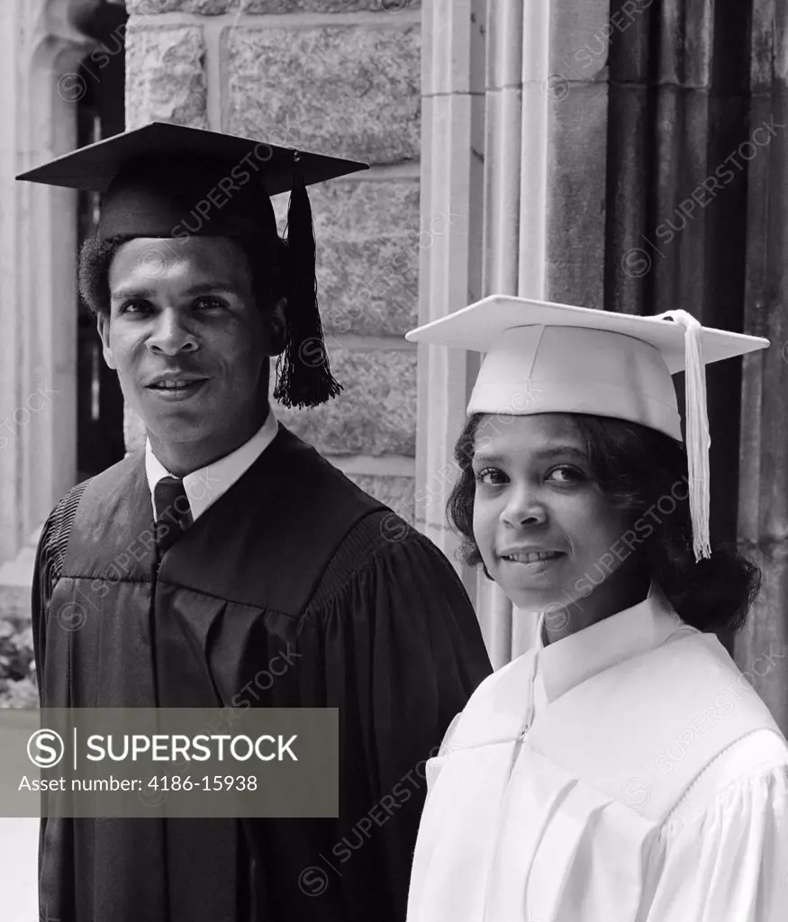 1970S Portrait African American Couple Man Woman Wearing Graduation Gowns Together Looking At Camera