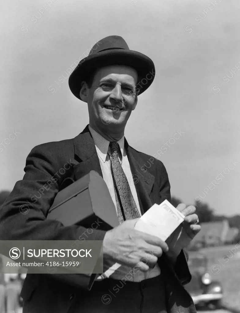 1930S Man In Suit & Hat With Lunch Pail Under Arm Holding Envelope With Paycheck