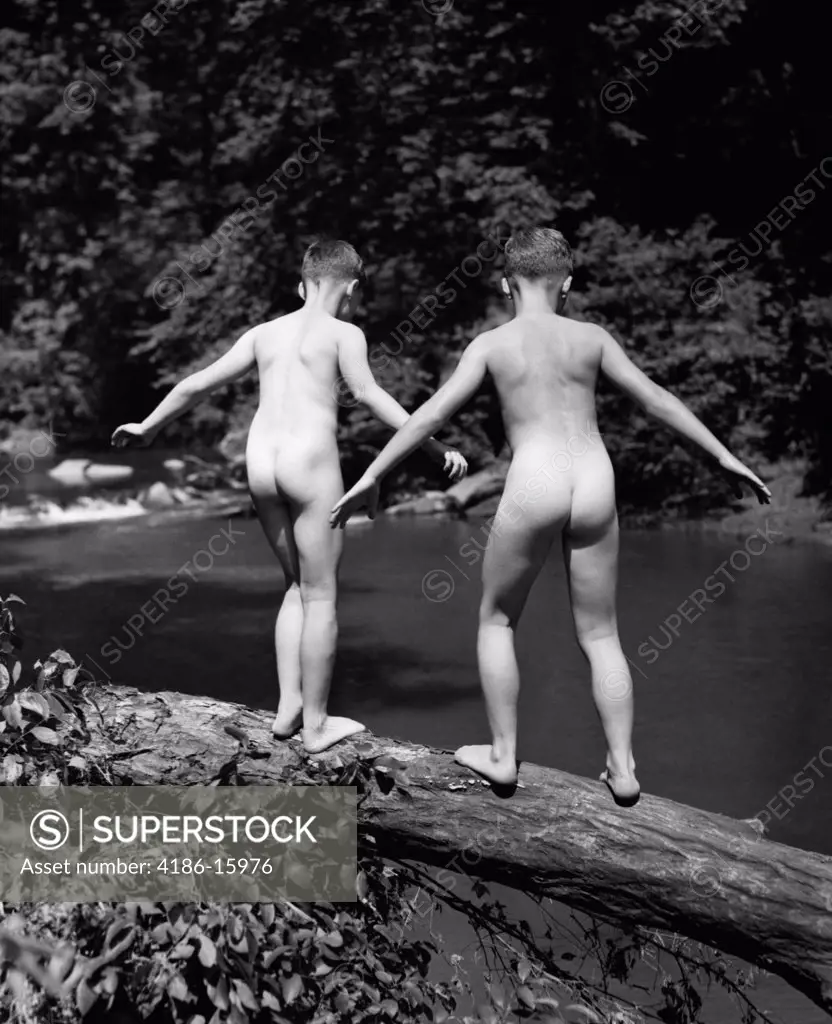 1930S Rear View Of Pair Of Skinny- Dipping Boys Getting Ready To Jump Off Of Fallen Log Into Creek