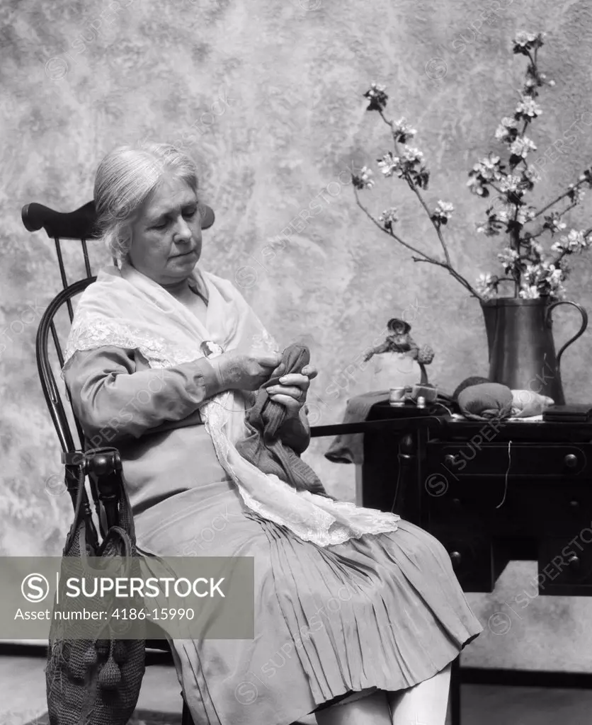 1920S Elderly Woman Sitting In Rocking Chair Darning Sock