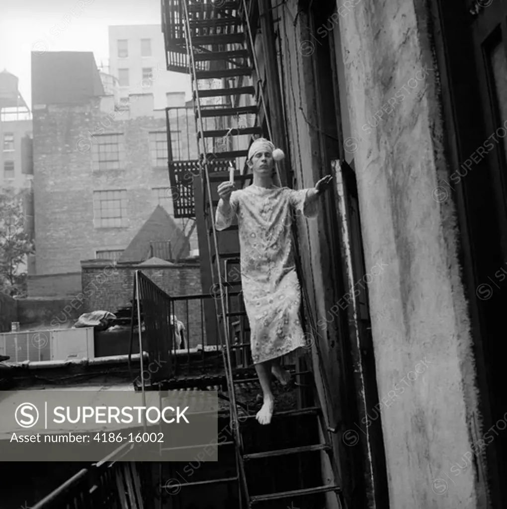 1970S Man In Nightgown And Cap Carrying Candle Sleepwalking Down Fire Escape Outdoor