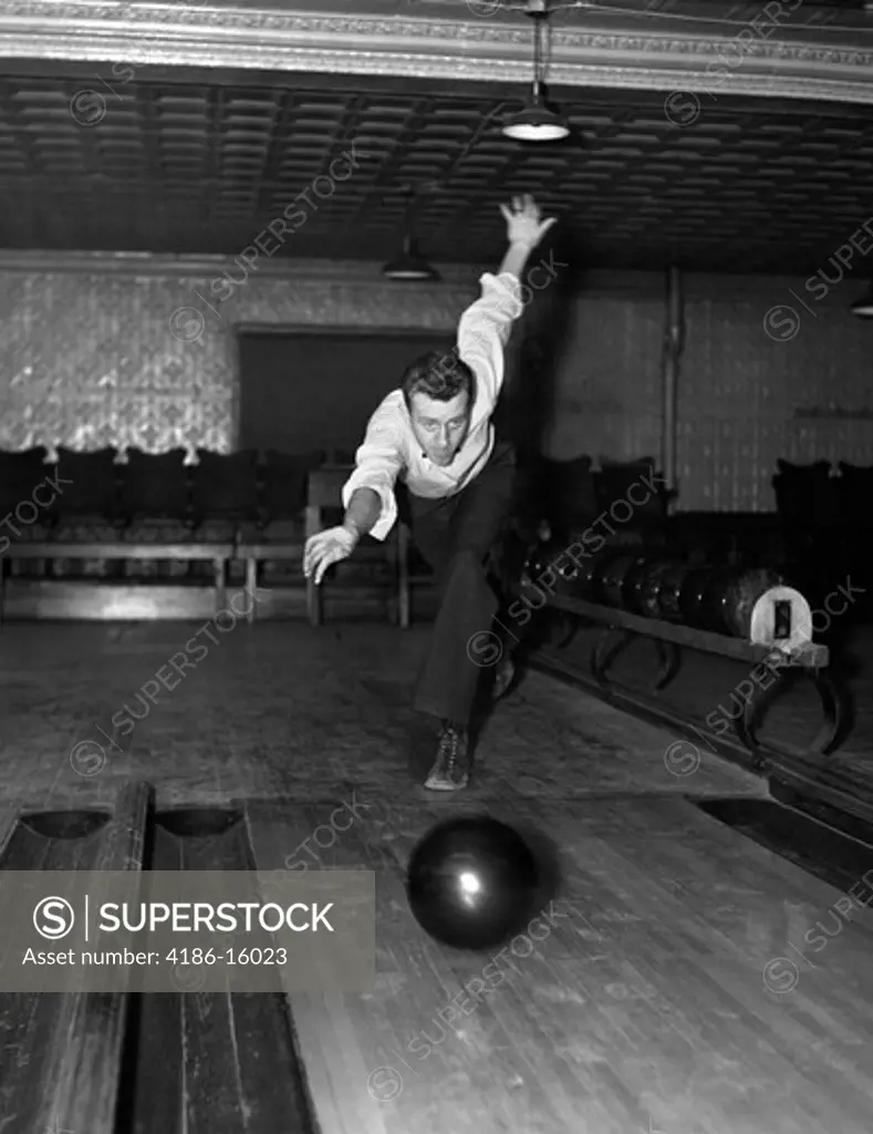 1930S Man Bowling Just Releasing Ball Into Alley