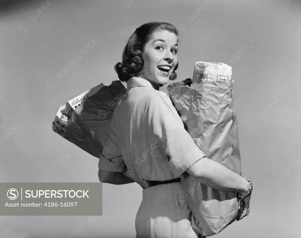1950S Smiling Woman Carrying Grocery Bags Both Hands Looking Back Over Shoulder