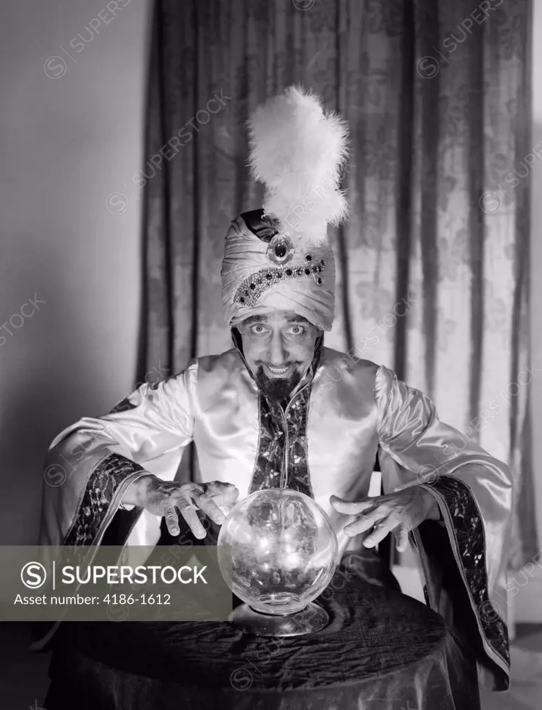 1950S Portrait Man Soothsayer Swami Fortune Teller Wearing Robe And Feather In Turban Gazing Over Crystal Ball