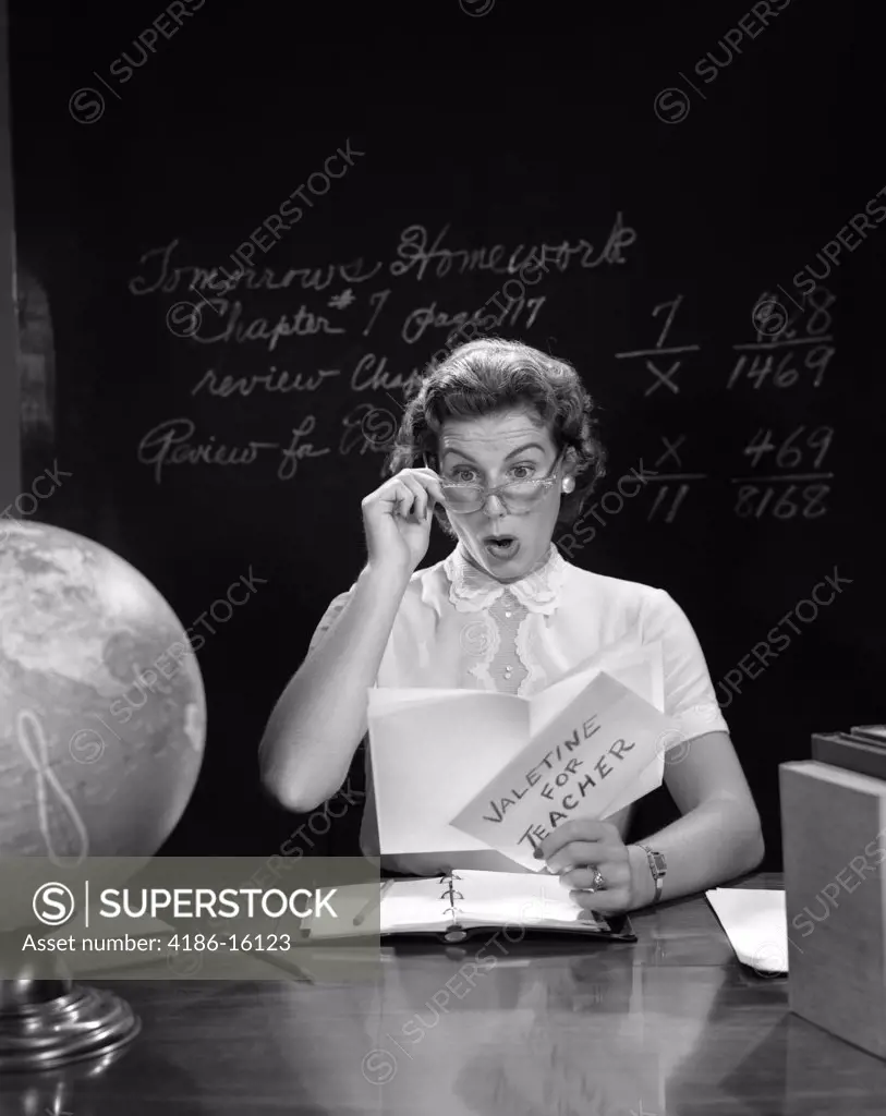 1950S School Teacher At Desk Hand To Glasses Expression Of Surprise Opening A Valentine For Teacher Globe Blackboard