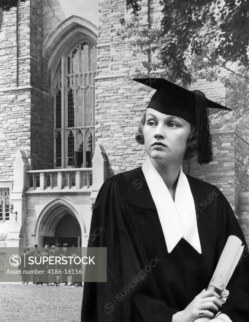 1930S Woman Graduate Cap Gown Holding A Diploma Standing In Front Stone Building Sad Serious Expression
