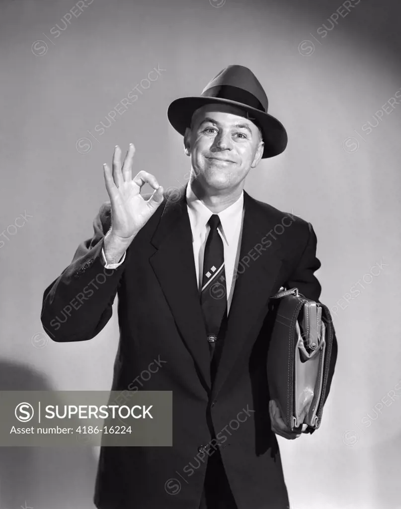 1950S Man Businessman Salesman Making Okay Sign With One Hand Carrying Briefcase Wearing Hat