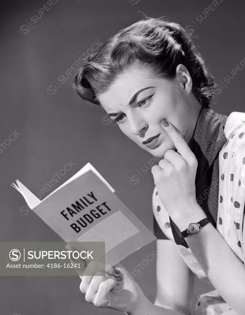 1950S Woman In Apron Finger On Cheek Looking At Family Budget Book