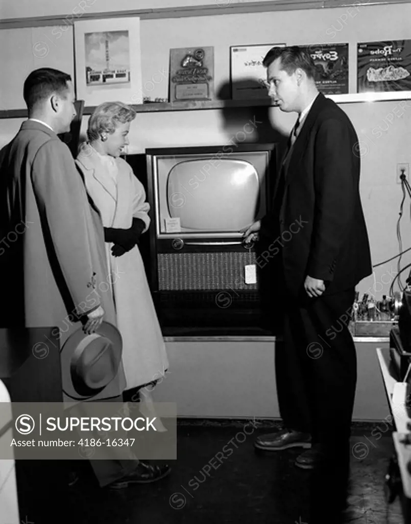 1950S Couple With Salesman In Electric Appliance Store Shopping For Television