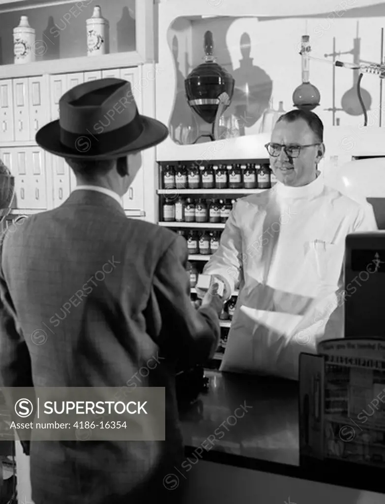 1950S Pharmacist Giving Prescription To Man Customer
