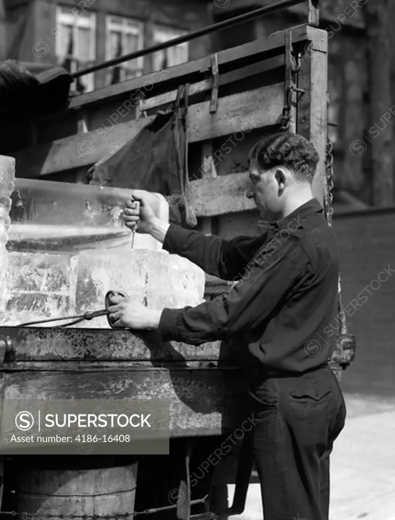 1930S Ice Delivery Man Standing At Back Of Truck Holding Tongs In One Hand & Putting Ice Pick In Block Of Ice With Other