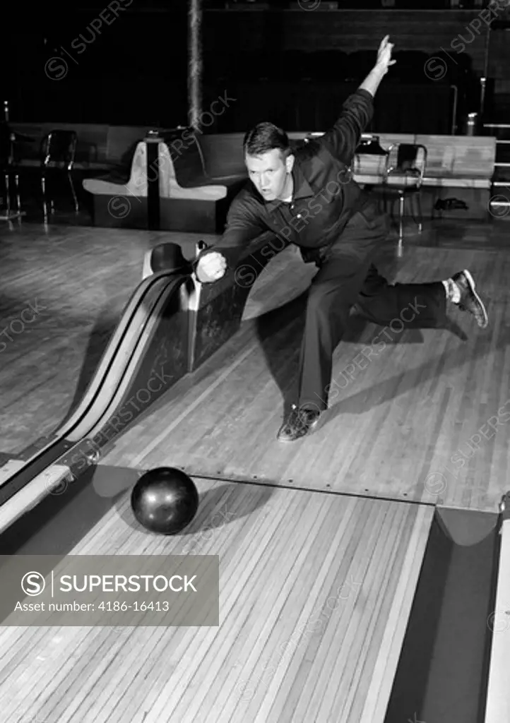 1950S Man Dressed Entirely In Black Letting Go Of Bowling Ball Holding Proper Form