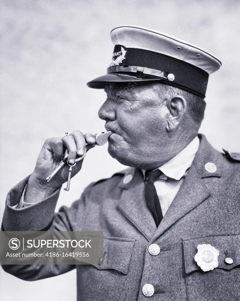 1920s 1930s TRAFFIC POLICEMAN BLOWING WHISTLE WEARING UNIFORM
