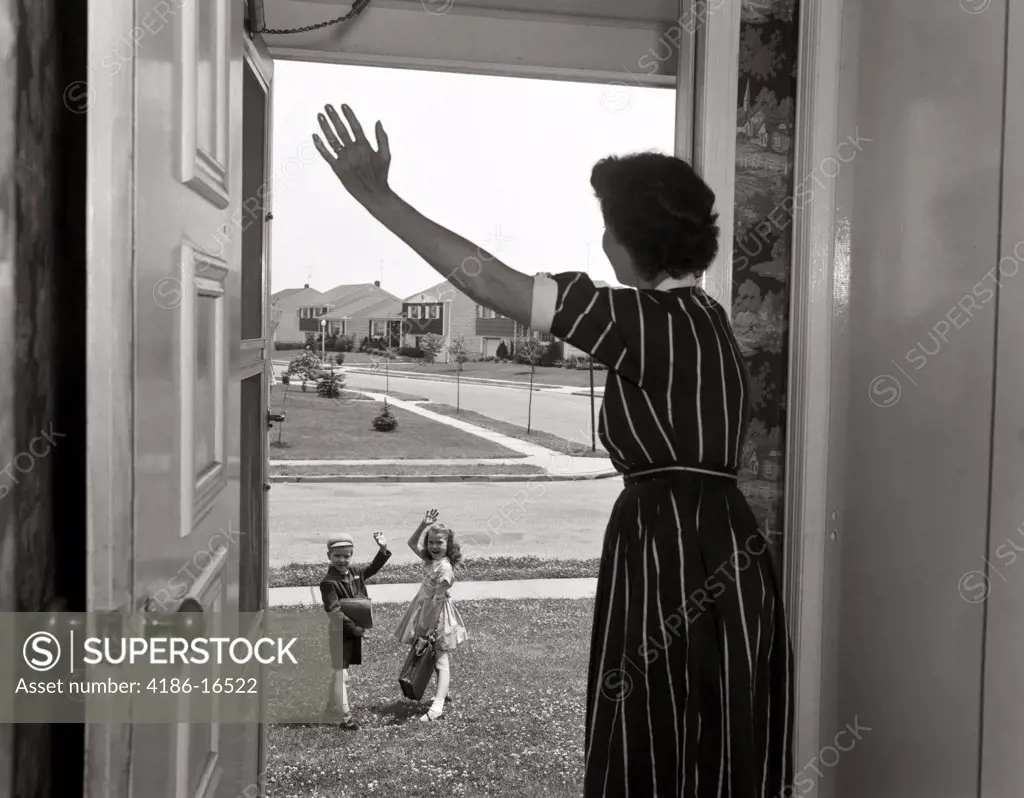1950S Mom In Doorway Waving At Boy & Girl Going To School