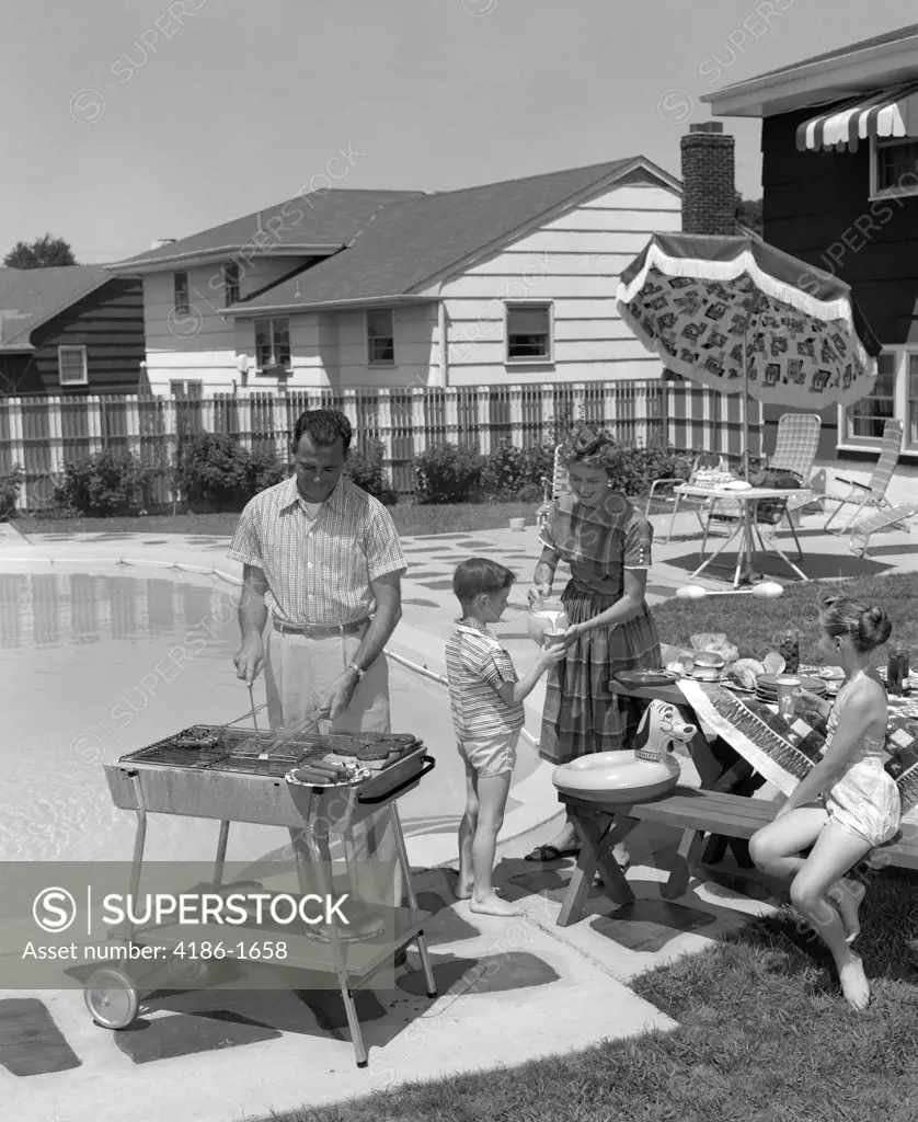 1950S Family In Backyard Beside Pool Having Cookout Of Hot Dogs & Hamburgers