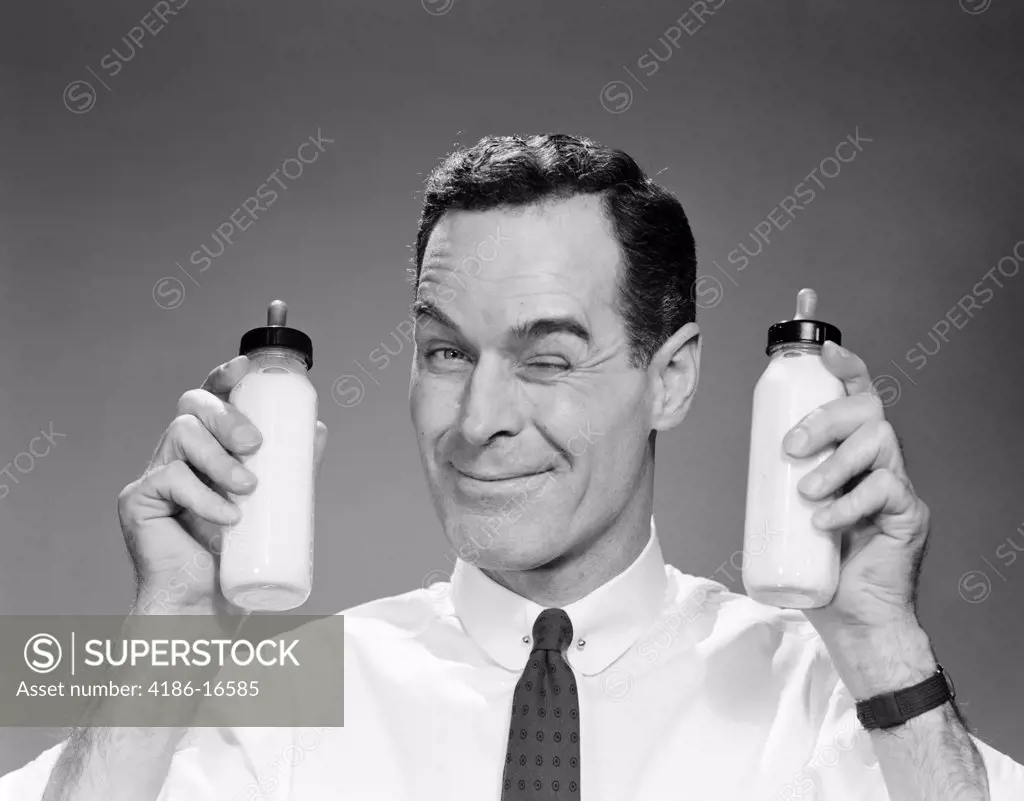 1960S Man In Shirt And Tie Winking At Camera Holding Two Baby Milk Bottles