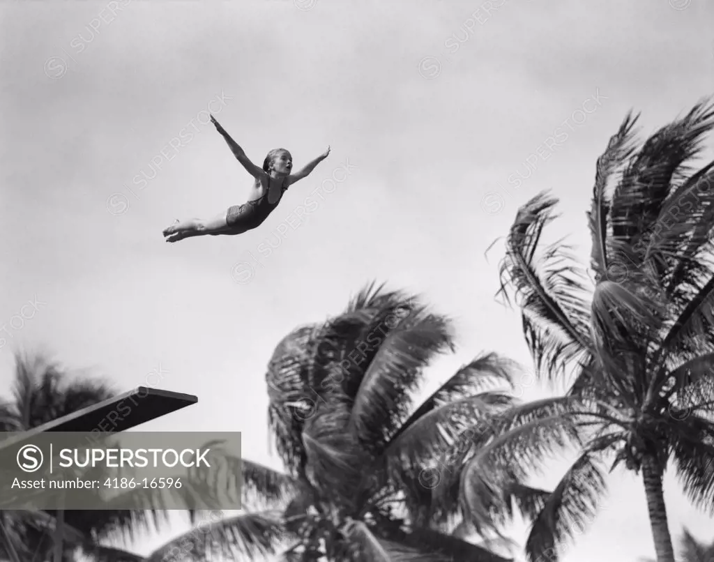1930S Girl In Mid Air Diving Into Swimming Pool Palm Trees In Background