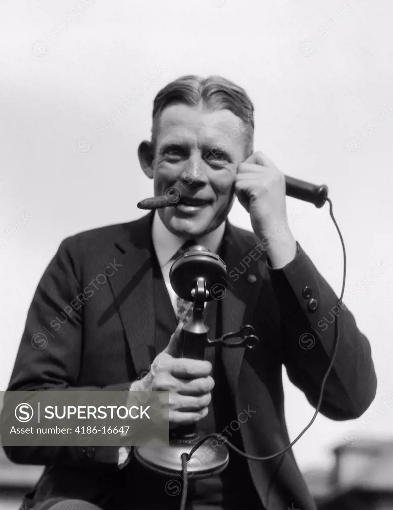 1920S Portrait Of Businessman Talking On Candlestick Phone Smoking Cigar Office Indoor