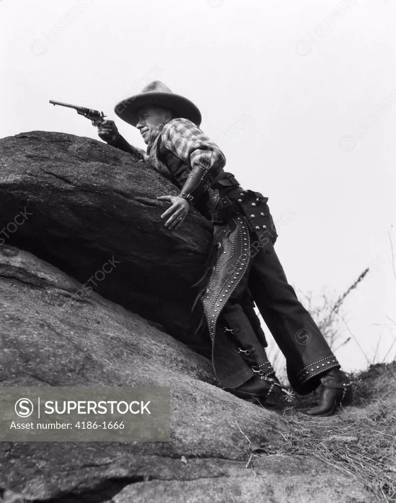 1920S Cowboy Among Rocks Aiming Revolver