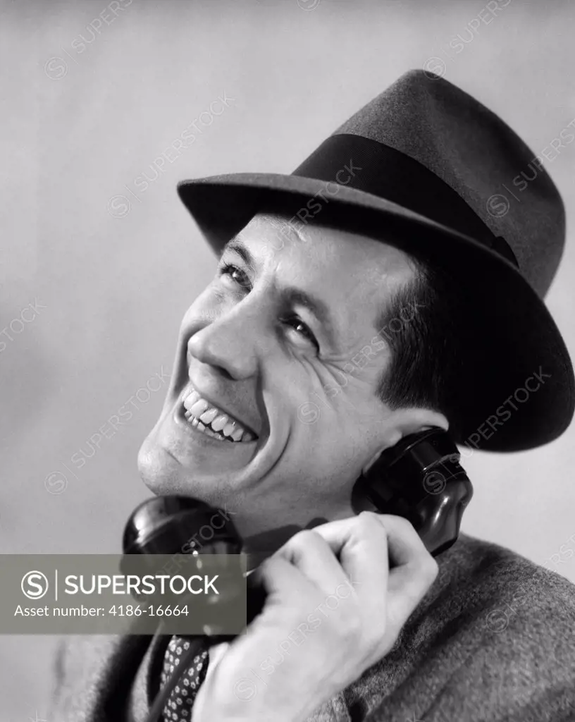 1930S Close-Up Of Man In Suit And Fedora Hat Smiling While Talking On Phone