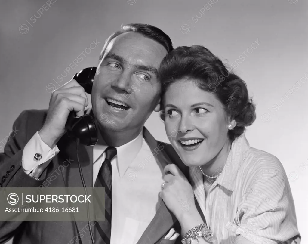 1950S Man On Telephone Woman Leaning In Listening Both Smiling