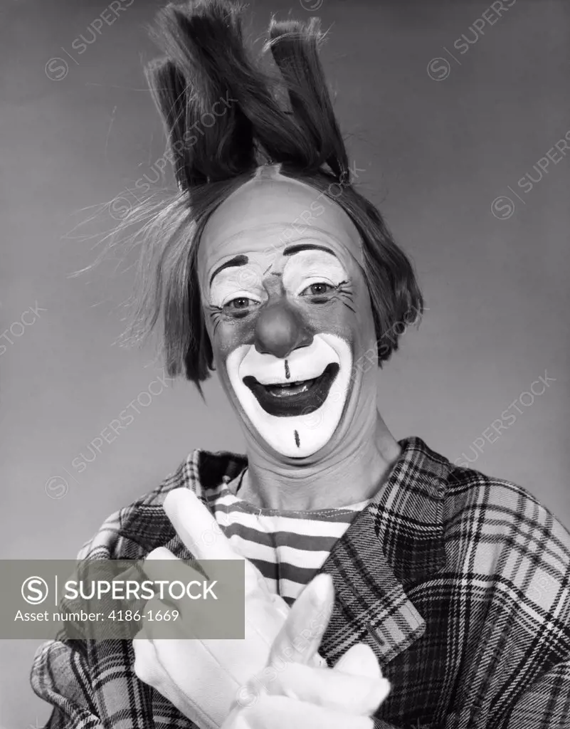 1960S Smiling Clown With White Gloved Crossed Hands And Hair Standing On End Studio Inside