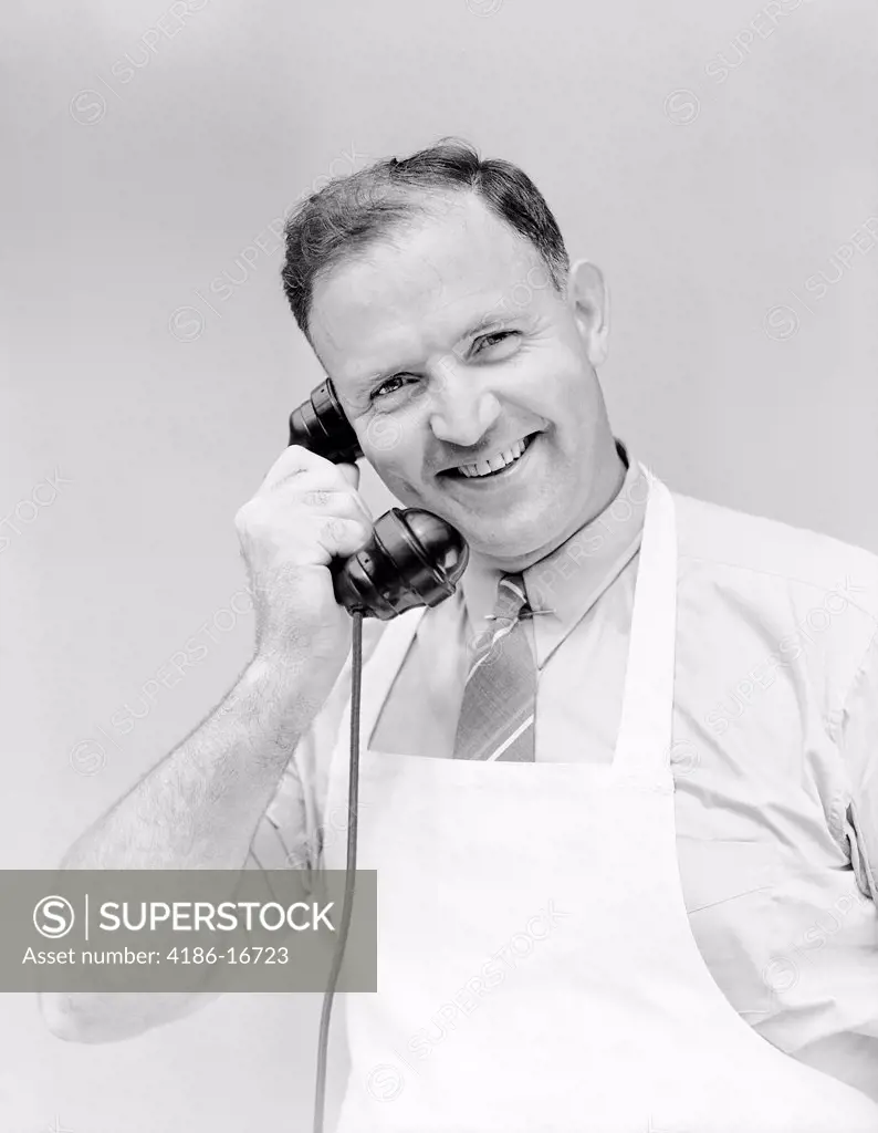 1930S 1940S Man Wearing White Apron Smiling Talking On Telephone Store Clerk Butcher Baker Grocer Service Business 