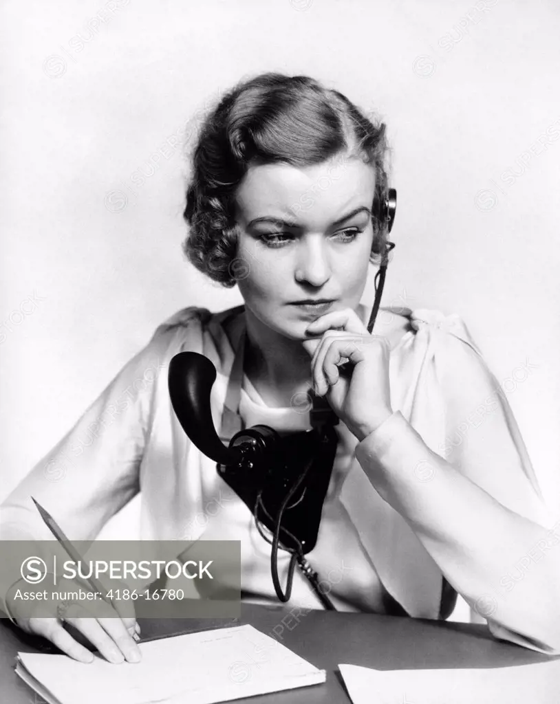 1930S Portrait Business Office Woman Receptionist Wearing Headphones And Speaker Microphone Looking Worried And Concerned
