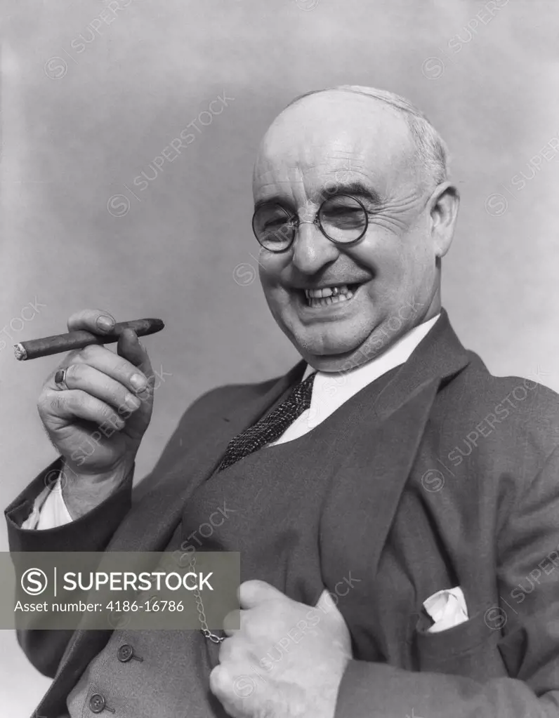 1930S Elderly Businessman In 3-Piece Suit & Glasses Leaning Back Smiling With Cigar In Hand