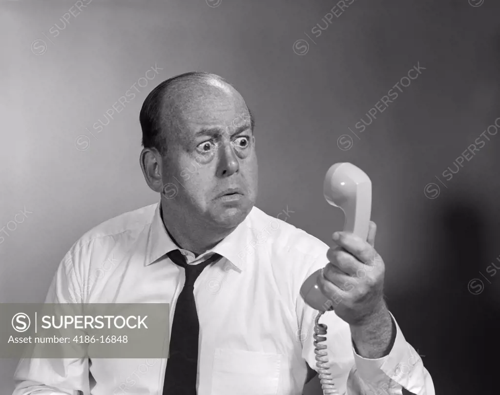 1960S Balding Man Looking Angry Into Telephone Receiver