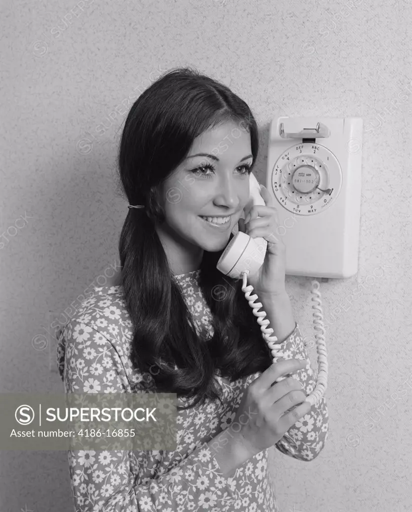 1960S 1970S Smiling Teenage Girl Talking On Rotary Wall Telephone