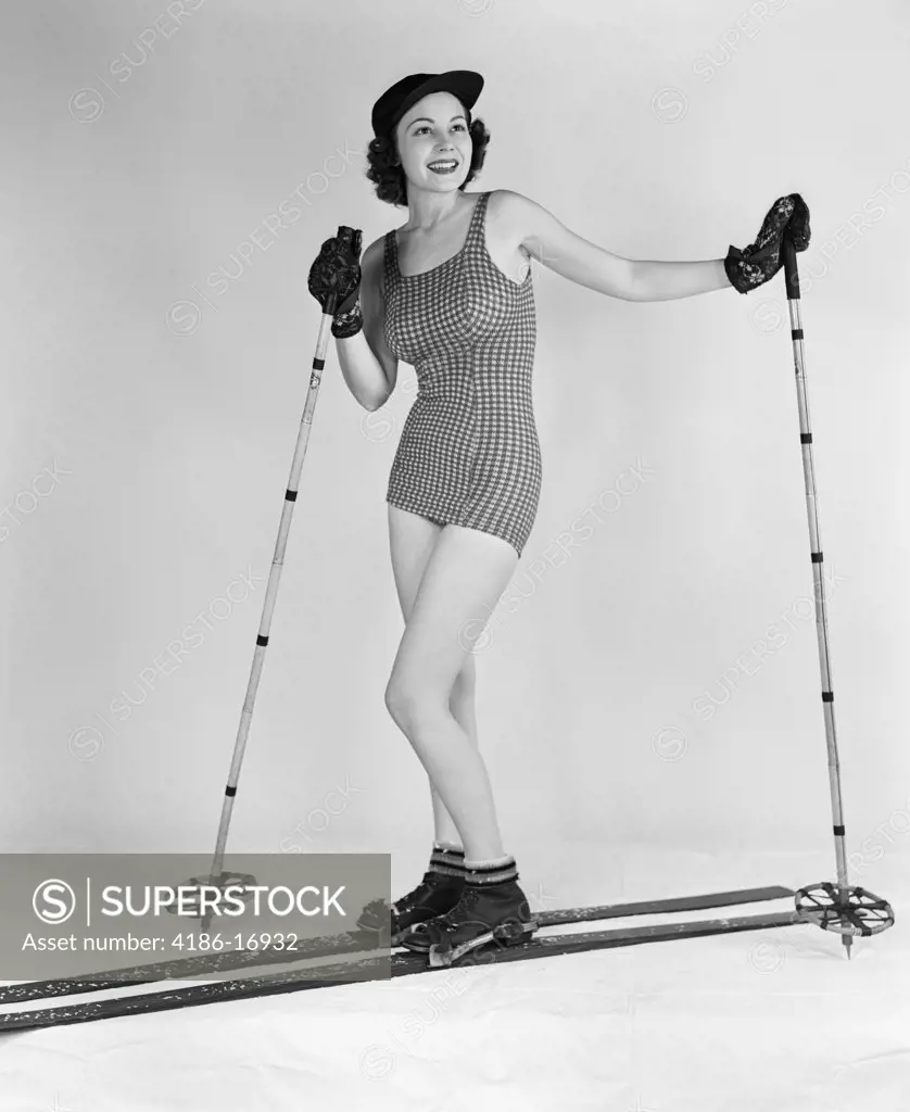 1930S Smiling Woman Posing In Studio On Wood Skis Wearing Bathing Suit Ski Hat Gloves Boots Holding Bamboo Ski Poles