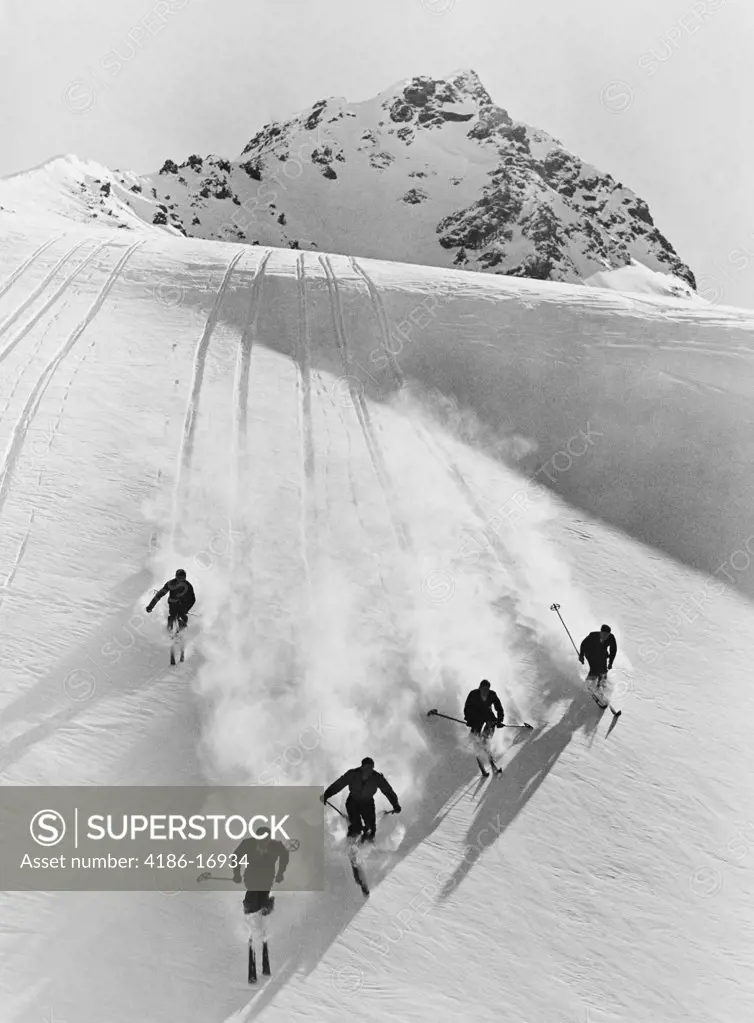 1920S 1930S Five Men Skiing Down Snow Covered Alps Switzerland