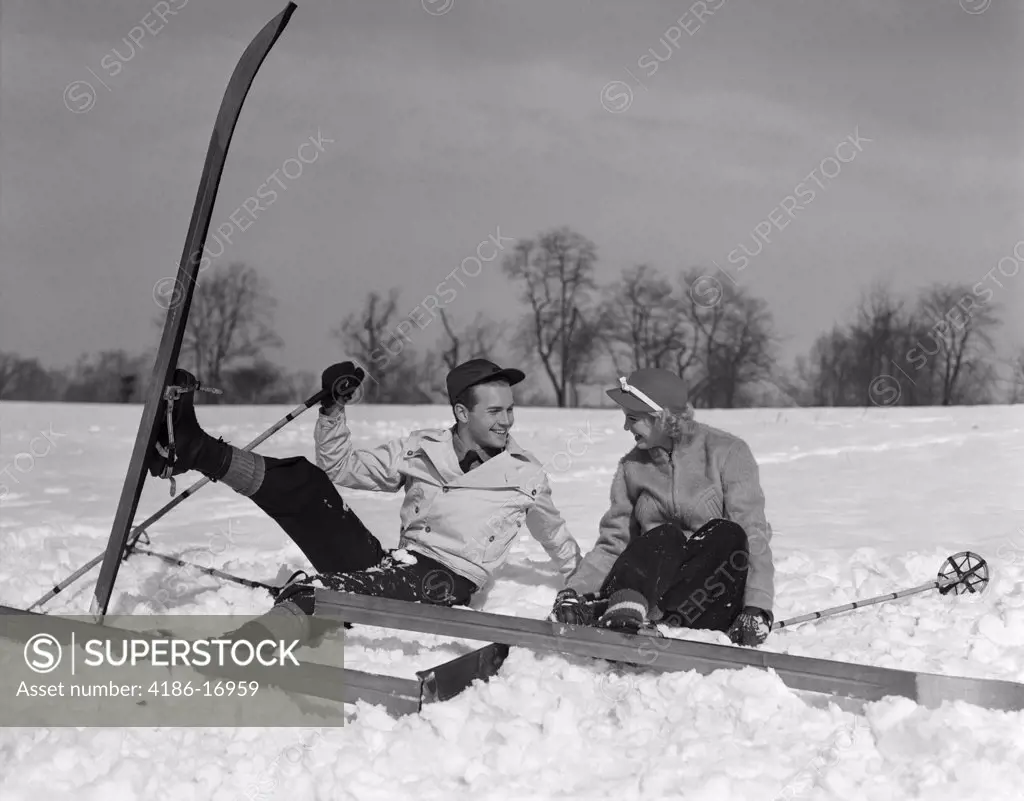 1930S Couple Man And Woman On Skis Falling In Snow Laughing