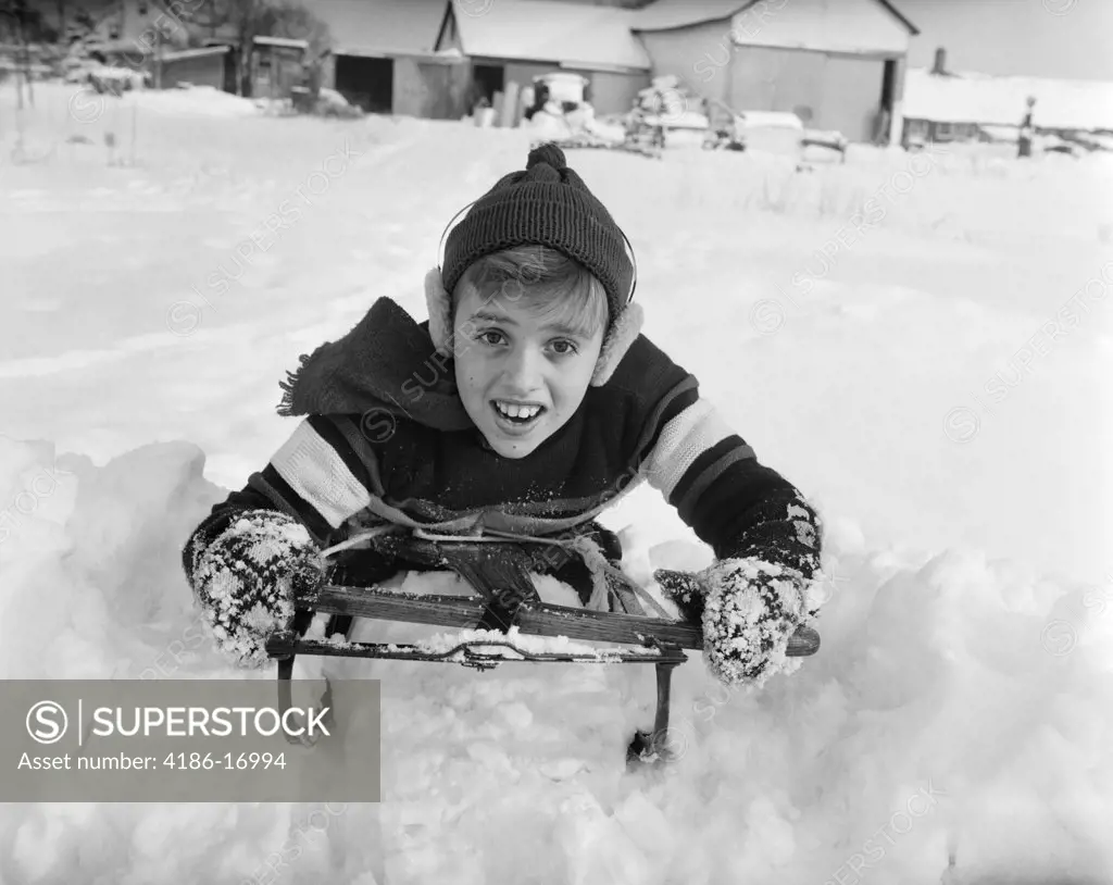 1950S Boy On Sled In Snow Looking At Camera