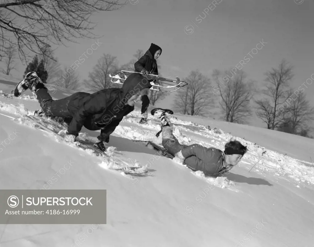 1960S 3 Boys Sledding Running Down Hill In Winter Snow