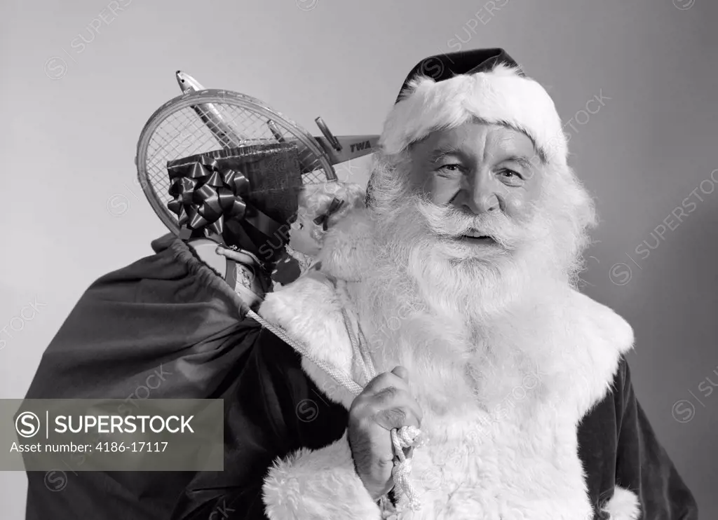 1960S Portrait Of Smiling Santa Claus With Sack Of Christmas Toy Presents Slung Over His Shoulder