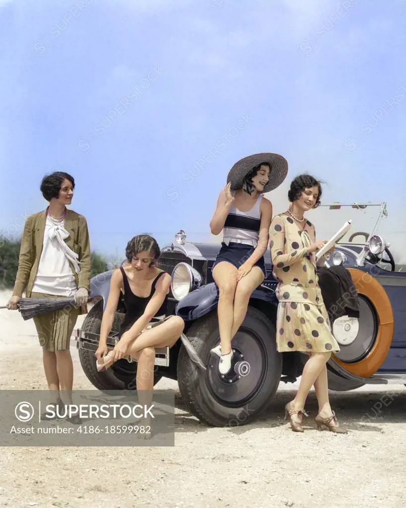 1920s GROUP OF FOUR WOMEN IN CASUAL SEASHORE CLOTHES GATHERED AROUND CONVERTIBLE CAR TWO IN DRESSES & TWO IN BATHING SUITS