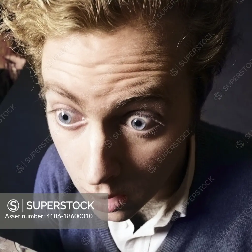 1970s EXTREME CLOSE-UP OF STARTLED SURPRISED YOUNG MAN CHARACTER WITH BULGING BUG-EYES AND MESSY HAIR