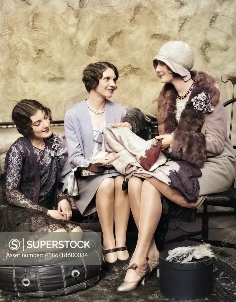 1920s WOMAN IN COAT & HAT BACK FROM SHOPPING SHOWING NEW PURCHASES TO TWO FRIENDS