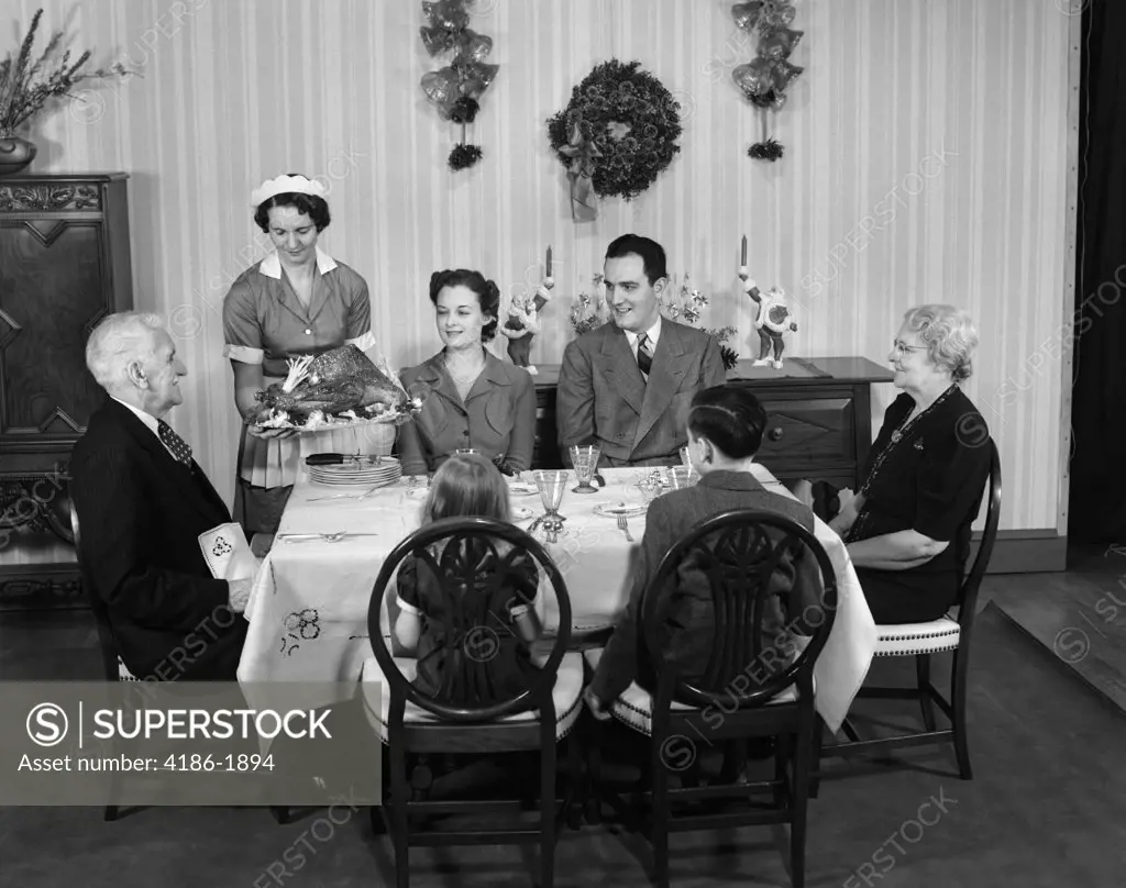 1940S Two Generation Family In Dining Room Being Served Christmas Turkey By Maid