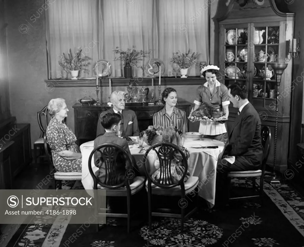 1940S Two Generation Family In Dining Room Thanksgiving Turkey Being Served By Maid