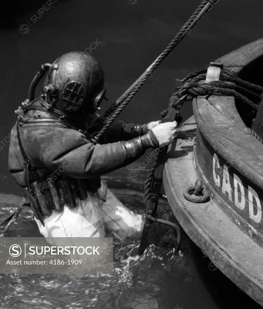 1930S Side View Of Diver In Pressure Suit Descending Into Water From Side Of Boat
