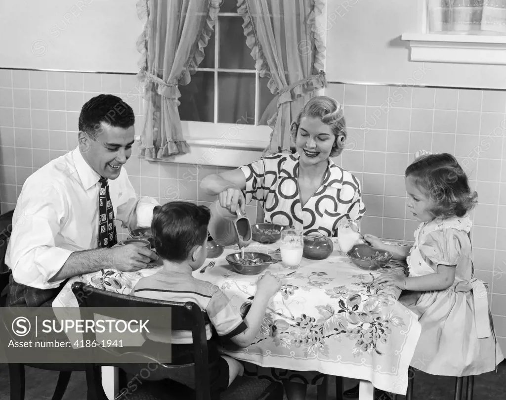 1950S Family Sitting At Kitchen Table Having Breakfast